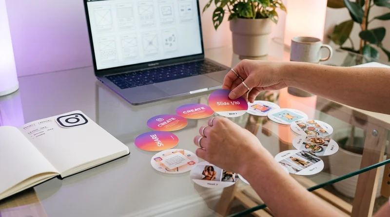 Manos de diseñador organizando diapositivas circulares de Instagram sobre mesa