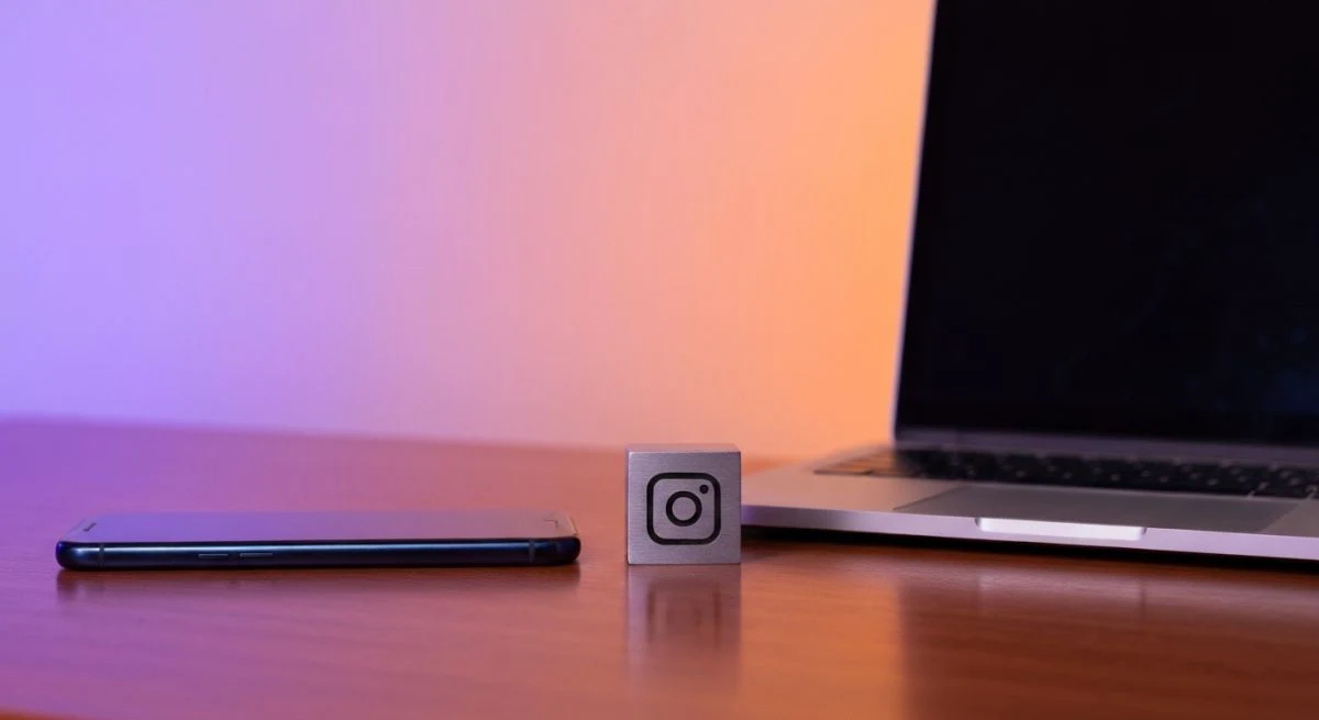 Escritorio con smartphone y portátil bloque grabado con glifo cámara Instagram