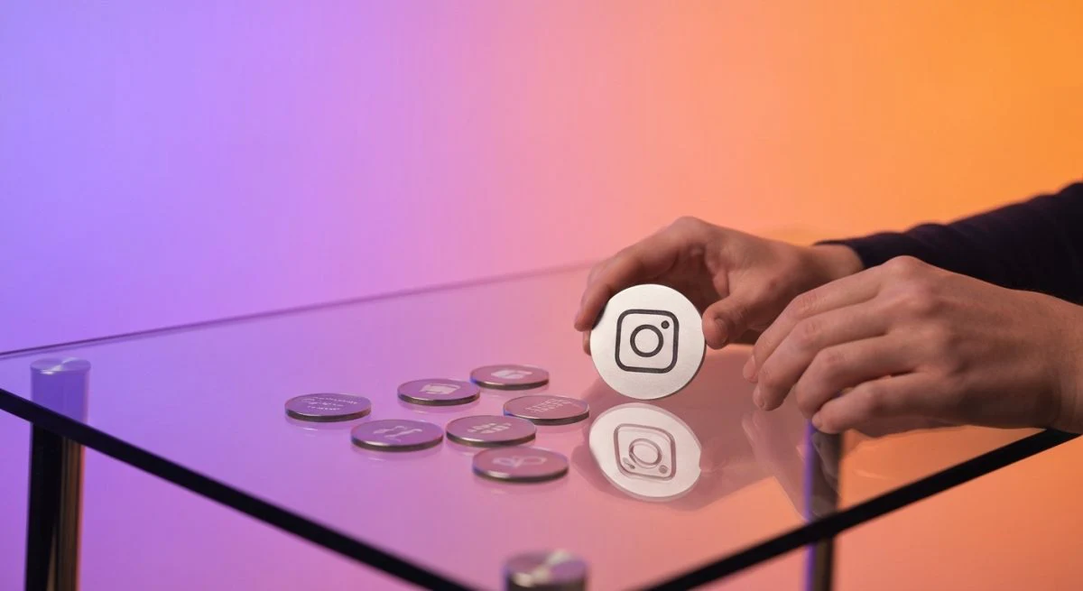 Manos de creador organizan tokens de monetización con logo Instagram