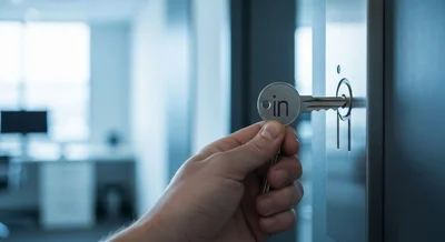 Mano sosteniendo llave plateada con logo in en la cerradura